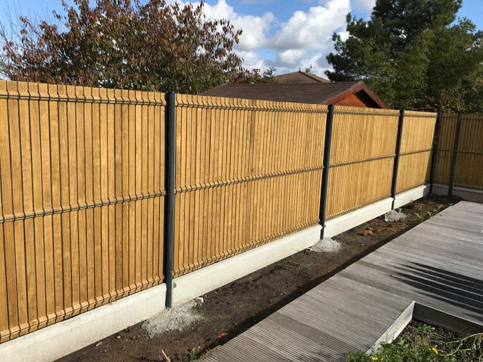 Pose d'une clôture rigide sur un terrain en pente : Un article